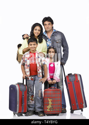 FAMILY OF FOUR going on a holiday with suitcases Stock Photo