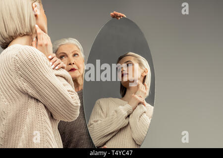 Nice pleasant young woman touching her hand Stock Photo