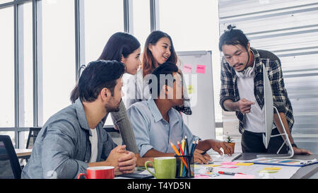 Creative director team lead brainstrom branding project with designer team at meeting table with desktop computer.discussion idea in creative office Stock Photo