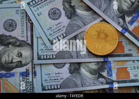 Golden Bitcoins on US dollars. Digital currency close-up. Crypto currency top view. Real coins of bitcoin on banknotes of one hundred dollars. Exchang Stock Photo