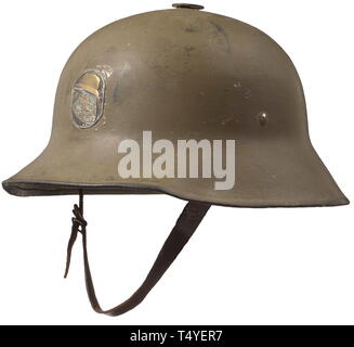 A Berndorf helmet - home defense league Steiermark. The helmet with typical olive green paint, lateral rivets with vestiges of intact colour, the upper surface with ventilation opening, the front with an applied emblem of the Styrian home defense league (a panther and steel helmet). Three-section inner liner and brown chin strap, one flap and the shell interior with painted-on number '120'. The helmet with signs of usage. Very rare. historic, historical, 20th century, Additional-Rights-Clearance-Info-Not-Available Stock Photo