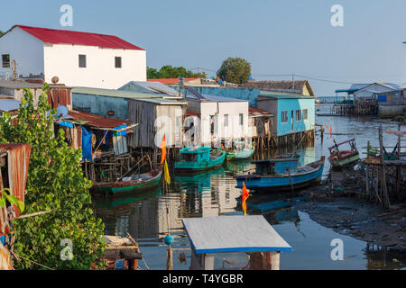Back of fishermens house and fishing boats on a calm little river in low tide water in the little fishing village Ham Ninh on Phu Quoc Island, Vietnam Stock Photo