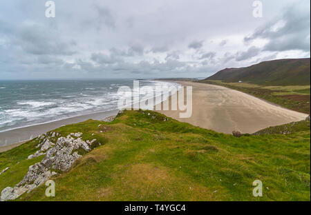 Rhossili bay on the West Wales Coast on the Gower Peninsula on a windy, blustery day in Summer with the white waves rolling in. Wales. Stock Photo