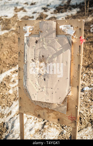 Target center after shooting with shotgun bullet gauge pellets. Outdoor shooting range Stock Photo