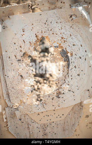 Target center after shooting with shotgun bullet gauge pellets. Outdoor shooting range Stock Photo