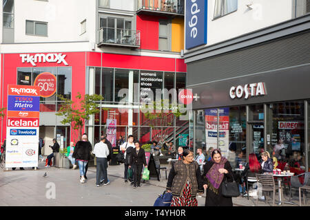 Customers of Costa Coffee consume drinks outdoors in the sunshine in a modern shopping and housing development, Wembley Central Stock Photo