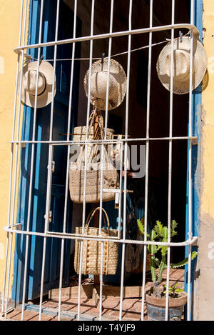 Hats on display in street window, behind iron bars in Trinidad, Cuba, Central America. Photo taken on 3rd of November, 2019 Stock Photo