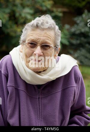 Elderly woman feeling very cold due to freezing temperatures Stock Photo