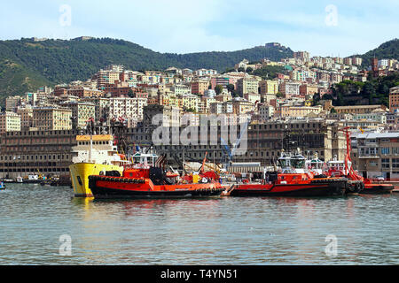 Tugboats in the Genoa harbor, sea view with cityscape Stock Photo