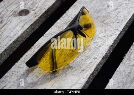 Yellow glasses on a wooden background. Glasses lie. Black orange glasses . Stock Photo