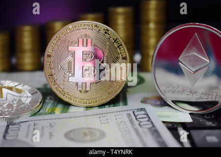 Physical coin Golden Bitcoin BTC and Etherum ETH on banknotes Euro and Us Dollar. Background of gold coins. Virtual money. Stock Photo
