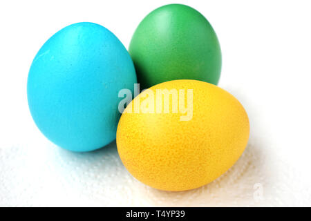 Three eggs are green, blue and yellow. Easter eggs on a white background Stock Photo