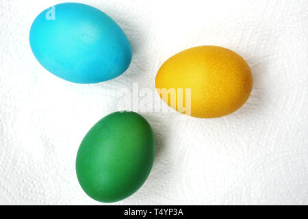 Three eggs are green, blue and yellow. Easter eggs on a white background Stock Photo