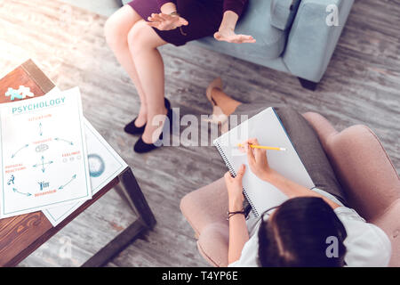 Above close-up shot of female psychologist making notes Stock Photo
