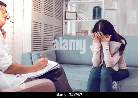 Despaired depressed young caucasian patient speaks with lady doctor ...