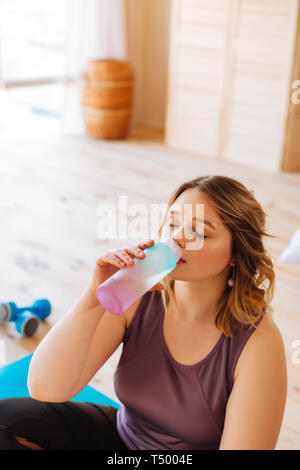 Feeling thirsty. Beautiful blonde woman enjoying her fresh water while feeling thirsty after yoga Stock Photo