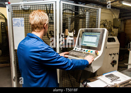A technician using a computer in industry Stock Photo