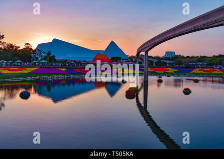 Orlando, Florida. March 19, 2019. Journey into imagination attraction, monorail road, colorful figures of mickey with flowers and lake on beautiful su Stock Photo