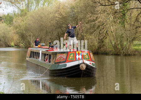 Kintbury, Berkshire, England, UK. A narroboat used for passenger canal trips on the Kennet and Avon Canal in Berkshire. Skipper holding mooring line Stock Photo