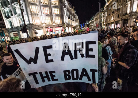 London, UK. 19th Apr, 2019. Two protesters holding a banner during the Extinction Rebellion Strike in London.An operation of hundreds of policeman was mobilized to remove the pink boat from Oxford Circus. Extinction Rebellion have blocked five central London landmarks for fifth day in protest against government inaction on climate change. Credit: Brais G. Rouco/SOPA Images/ZUMA Wire/Alamy Live News Stock Photo