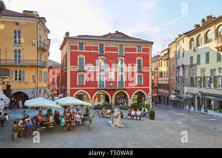 MONDOVI, ITALY - AUGUST 15, 2016: Moro square with people sitting at sidewalk tables in a sunny summer day, blue sky in Mondovi, Italy. Stock Photo