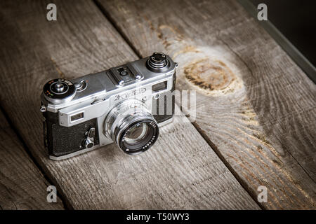 Old vintage photo camera with black background on a wooden table Stock Photo