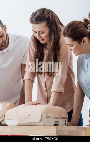 beautiful woman performing chest compression on dummy during cpr training class Stock Photo
