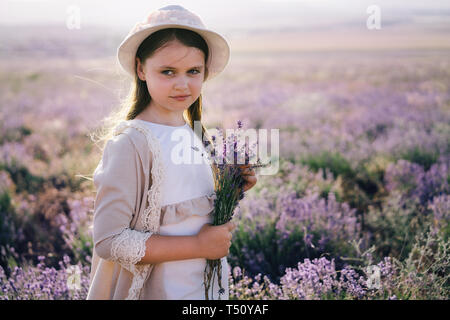Pretty girl with long hair in a linen dress and a hat Stock Photo