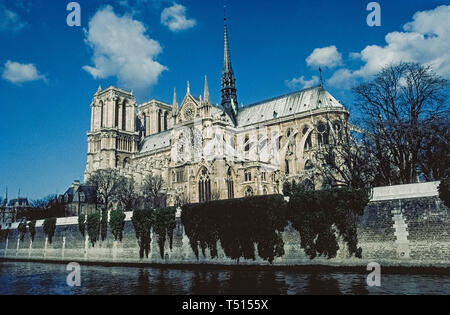A view from the River Seine of the gothic Notre-Dame de Paris, the famous Catholic cathedral in the French capital that is one of Europe's most popular tourist attractions. This photograph was taken before the historic church suffered major damage by a disastrous fire in April, 2019, and was closed for restoration. Construction of the ancient stone structure began in the 12th Century and featured ornate medieval architecture that included twin bell towers, stained-glass rose windows, flying support buttresses and the soaring wooden central spire (that was destroyed in the fire). Stock Photo
