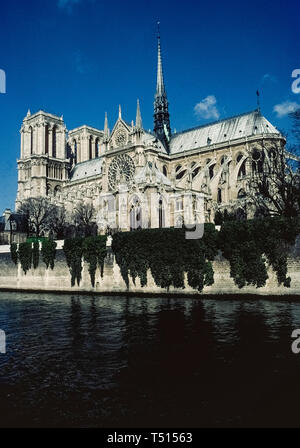 A vertical view from the River Seine of the gothic Notre-Dame de Paris, the famous Catholic cathedral in the French capital that is one of Europe's most popular tourist attractions. This photograph was taken before the historic church suffered major damage by a disastrous fire in April, 2019, and was closed for restoration. Construction of the ancient stone structure began in the 12th Century and featured ornate medieval architecture that included twin bell towers, stained-glass rose windows, flying support buttresses and the soaring wooden central spire (that was destroyed in the fire). Stock Photo