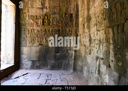 Bas-relief carvings on walls in a corridor in Bayon temple in Angkor Thom, Angkor Archaeological Park, Cambodia. Stock Photo