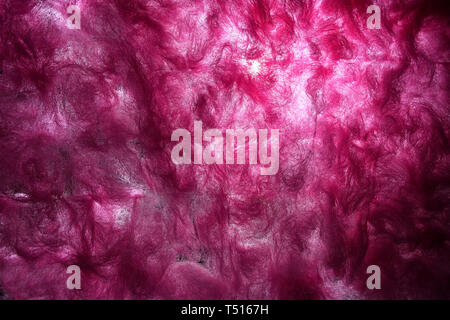 Pink abstract background design with the light breaking through textile fibers of cotton wool or synthetic insulation. Full frame closeup theme with d Stock Photo