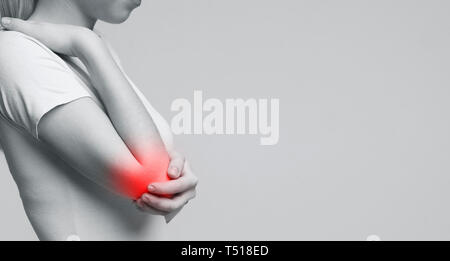 Cropped young woman suffering from painful elbow Stock Photo