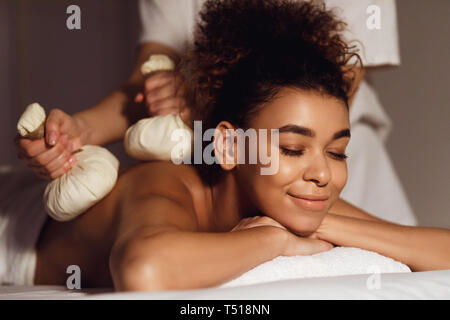 Body care. Spa body massage with hot herbal balls Stock Photo
