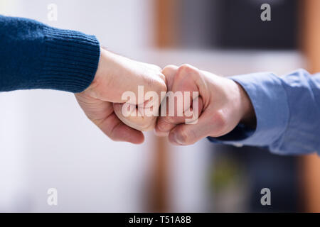Close-up Of Two Businessmen Making Fist Bump In Office Stock Photo