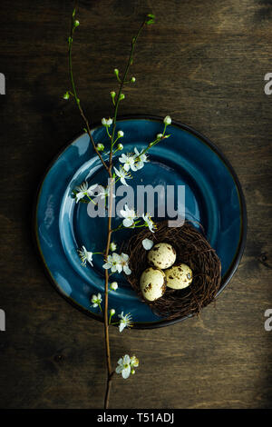 Feastive table setting for holiday Easter dinner decorated with blooming cherry  flowers on rustic table with copy space Stock Photo