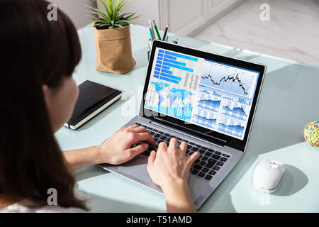 Close-up Of Businesswoman Analyzing Graph On Laptop At Workplace In The Office Stock Photo