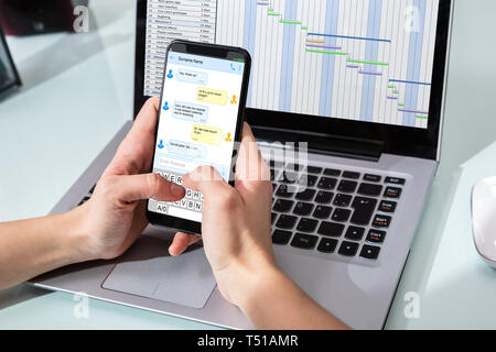 Close-up Of A Human's Hand Holding Smart Phone With New Messages On Screen Stock Photo