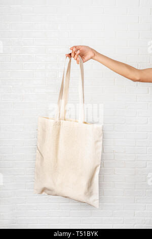 Female hand holding eco bag on white background Stock Photo