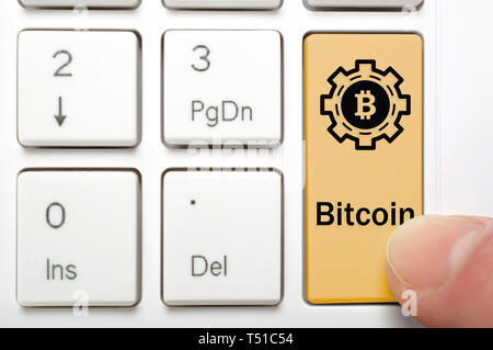 Pressing brown bitcoin key on keyboard Stock Photo