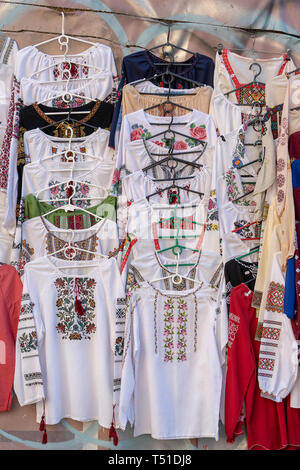 Display of embroidered Ukrainian slavic women and men traditional shirts embroidery clothing in outdoor flea market in Kiev, Ukraine. Close up. Ethnic Stock Photo