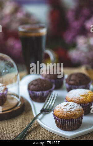 Tasty lemon and chocolate cupcakes in rustic interior Stock Photo