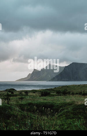 A minimal dark cloud mountain and coast landscape in Lofoten Norway Stock Photo