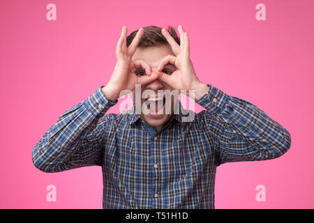 Young handsome man showing hero or owl sign or like wearing glasses Stock Photo