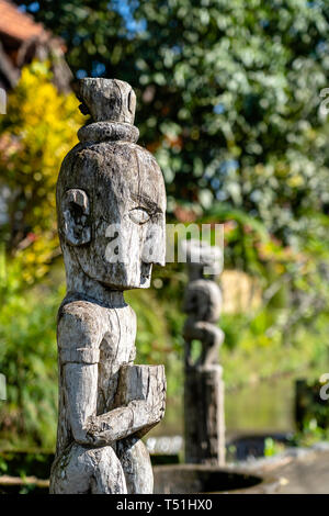 Balinese ancient wooden statue on street in Ubud, island Bali, Indonesia. These figures of the gods protect the house from evil spirits. Close up Stock Photo