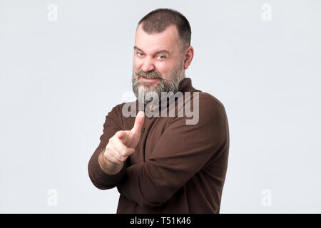 Angry irritated mature man pointing index finger on camera Stock Photo