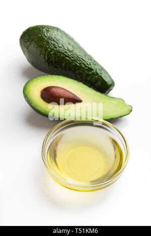 Fresh avocado and oil in glass bowl on white background. Vegetable fats concept Stock Photo