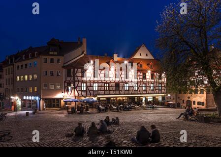 Young people on the square, historical restaurant in the old town in the evening, Tiergartnertorplatz, Nuremberg, Middle Franconia, Bavaria, Germany Stock Photo