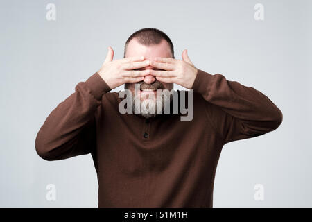 European mature man covering his face by hands Stock Photo