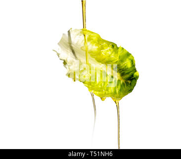Oil pouring on floating lettuce leaf. Stock Photo
